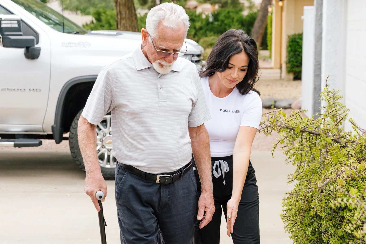 Prata Health registered nurse walking beside a patient using a cane during knee replacement recovery at home in Scottsdale