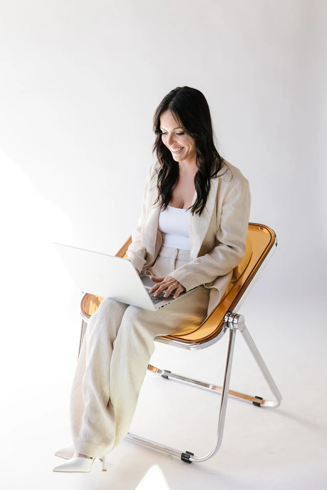 Founder Bianca Fabbo, RN, working on a laptop in a bright studio
